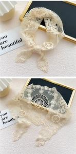 Détails d'un foulard en dentelle beige avec broderie florale et bords festonnés