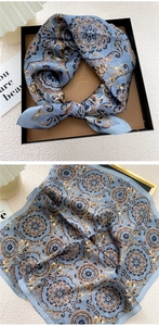 Detail of grey-blue silk scarf with vintage mandala pattern in an elegant gift box