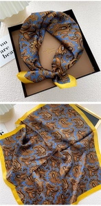 Macro shot of blue paisley silk scarf showing bright yellow edges and satin texture