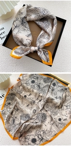 Detail of floral silk square scarf with orange borders in a premium gift box packaging