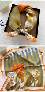Detailed view of white floral and striped silk scarf in premium black gift packaging