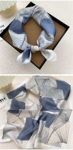 Detail of silk square scarf with geometric patterns in blue and grey in gift packaging