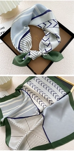 Detail of silk square scarf featuring geometric patterns in teal and blue shades