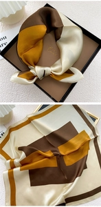 Close-up of elegant silk square scarf with geometric patchwork in earthy brown and beige