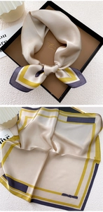 Detail of silk square scarf in champagne gold with geometric lines and bow accents