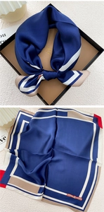 Detail of silk square scarf in navy blue with contrast trim and elegant gift box