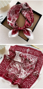Detail of red and ivory silk scarf featuring medieval knights and floral patterns