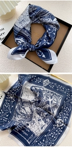 Detail of blue and white silk scarf with dragon motif and scrollwork tied on gift box