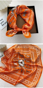 Detail of orange silk square scarf with horse print in premium gift box packaging