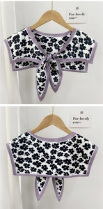 Detailed view of floral shawl collar with purple trim and delicate front tie ribbons