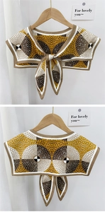 Detail of silk-like neck scarf with yellow geometric pattern and bow tie closure