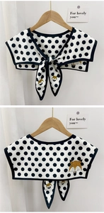 Detail of white polka dot decorative collar with bow tie and yellow fox print on back