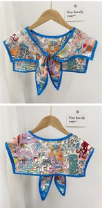Detail of cartoon print silk decorative collar with blue piping and ribbon bow tie