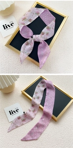 Detail of a thin silk twilly scarf with floral prints and white polka dots on purple