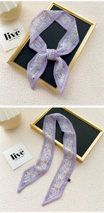 Detail of a thin purple twilly scarf with daisy floral print and pointed ends