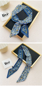 Detailed macro view of a floral blue twilly scarf with elegant yellow floral patterns