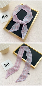 Close-up of pink floral twilly silk scarf with diagonal cuts and delicate flower patterns