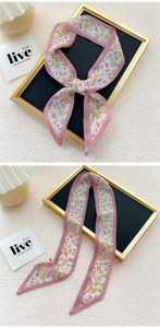 Detail of floral skinny scarf tied on a handle with pink borders and red flower print