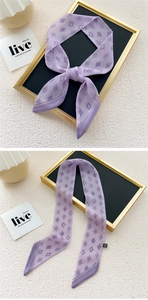 Detail of a purple narrow silk scarf with geometric diamond patterns and slanted edges