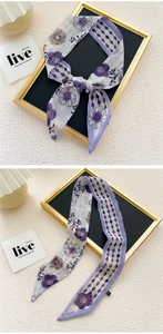 Detail of silk-like neck scarf with purple floral pattern and geometric diamond print