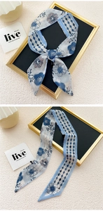 Detail of floral and lozenge pattern silk-like skinny scarf showing texture and hem