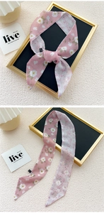 Detail showing the pink floral twilly scarf tied in a bow with light chiffon fabric