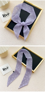 Detail view of purple skinny scarf with white heart patterns and elegant logo print