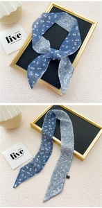 Close-up of double-sided silk scarf featuring blue floral and white cherry patterns