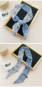 Close-up of a double-sided floral skinny scarf showing delicate purple and navy patterns