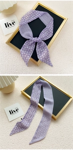 Detail of thin purple silk scarf featuring daisy floral patterns and plaid patchwork