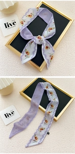 Detail of narrow silk scarf with orange floral pattern and purple polka dots