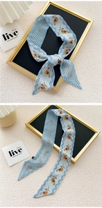 Detail of light blue silk scarf with yellow floral and polka dot patterns used as a bag tie