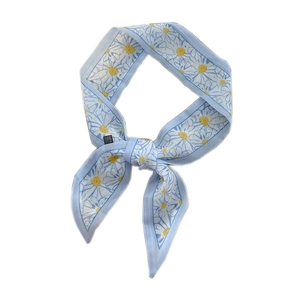 Narrow light blue silk scarf with white daisy print tied in a minimalist bow