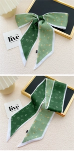 Detail van gebloemde zijden sjaal met groen patchwork en cartoonprint voor het haar