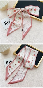 Detail van een zijden sjaal met bloemenprint, rozen en elegante roze randen