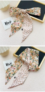 Detailopname van zijden sjaal met bloemen en stippen als stijlvol haaraccessoire