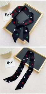 Vue détaillée d'une écharpe étroite noire à pois avec pointes et coutures précises
