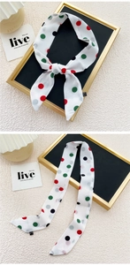 Détail d'un foulard en soie à pois noué en nœud sur un plateau de présentation chic