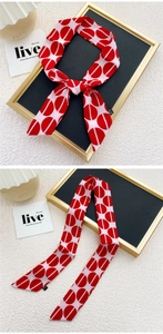 Détail d'un foulard étroit à motifs géométriques rose et rouge avec finitions soignées