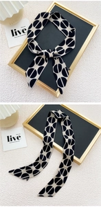 Détail d'un foulard étroit avec motifs géométriques noir et blanc et bouts pointus