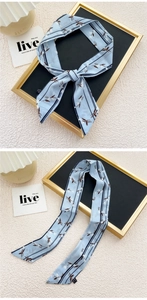 Détail d'un foulard étroit bleu clair avec motif floral et rayures pour sacs à main