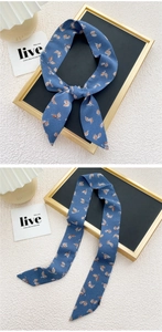 Détail d'un foulard en soie bleu marine avec motif de feuilles d'automne comme bandeau
