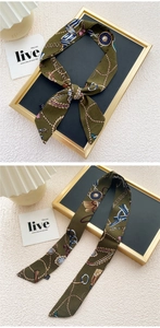 Détail d'un foulard en soie vert olive avec chaînes dorées et motifs de cordes nautiques