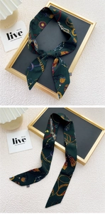 Détail d'un foulard étroit vert foncé avec imprimé équestre vintage et harnais