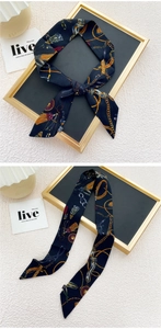 Détail d'un foulard fin en soie avec imprimés chaînes dorées et glands colorés