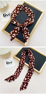 Détail d'un foulard en soie léopard marron avec nœud et texture de tissu 100% polyester