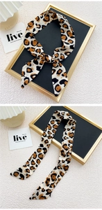 Détail d'un foulard étroit en soie à imprimé léopard pour cheveux ou décoration de sac