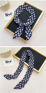 Détail d'un foulard étroit bleu marine à motif mouettes attaché en un nœud élégant