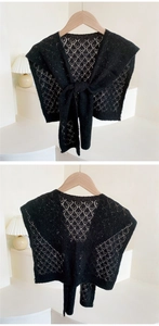 Detail of black hollow knit shawl showing diamond crochet texture and front tie closure
