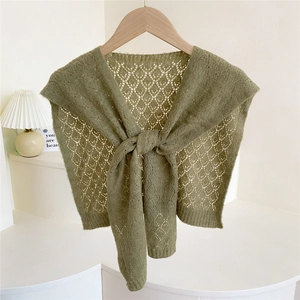 Grass green knitted shawl with hollow diamond texture tied on a wooden hanger